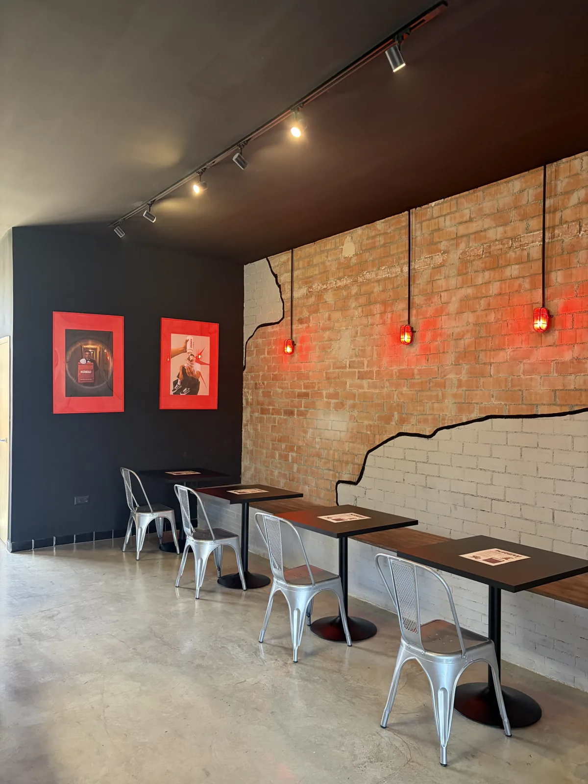 Sala del local con pared de ladrillo y luces rojas